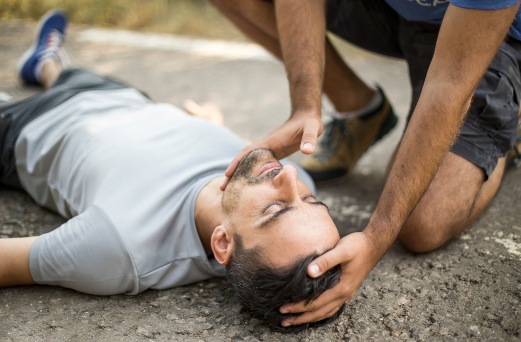Online First Aid Course Brisbane - first aider tilting casualty head with casualty laying on the ground